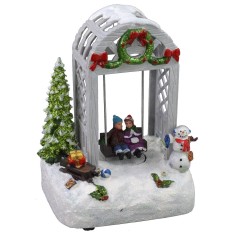 Escenario navideño niños en el columpio funcionando a pilas de