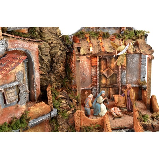 Belén iluminado con cascada funcionando, completo con estatuas.