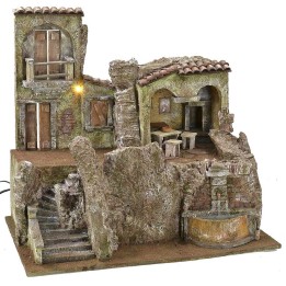 Aldea iluminada con casa, taberna y fuente funcionando de