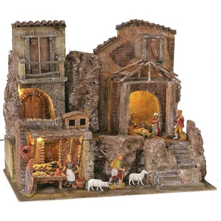 Illuminated nativity scene complete with Landi statues with houses and shops