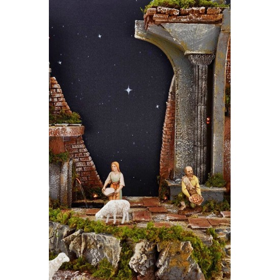 Pesebre completo de figuras Landi con cielo estrellado iluminado.