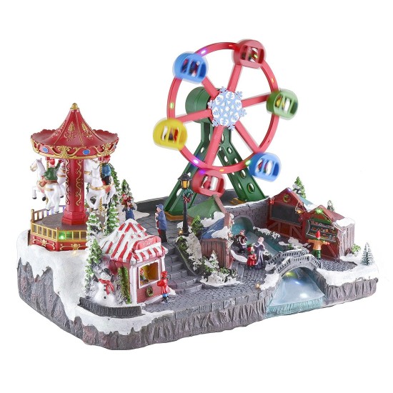 Parque de atracciones navideño con música e iluminación funcionando a