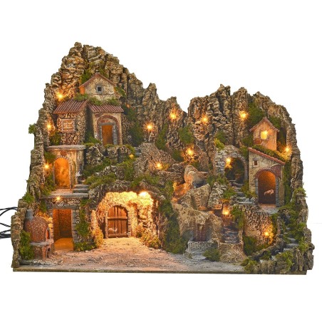 Illuminated nativity scene with cave, fountain, waterfall and fire