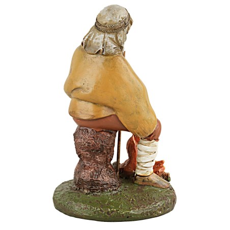 Shepherd with staff sitting in front of the fire in painted resin.