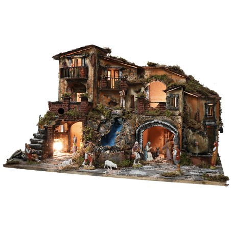 Illuminated nativity scene complete with statues, waterfall, fountain, and