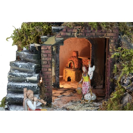 Illuminated nativity scene complete with statues, waterfall, fountain, and