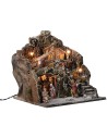 Illuminated nativity scene with village on mountain complete with statues