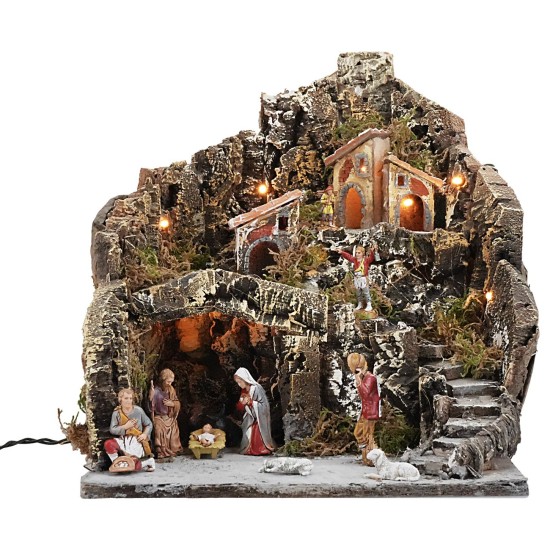 Pesebre iluminado con pueblo en montaña completo de estatuas.