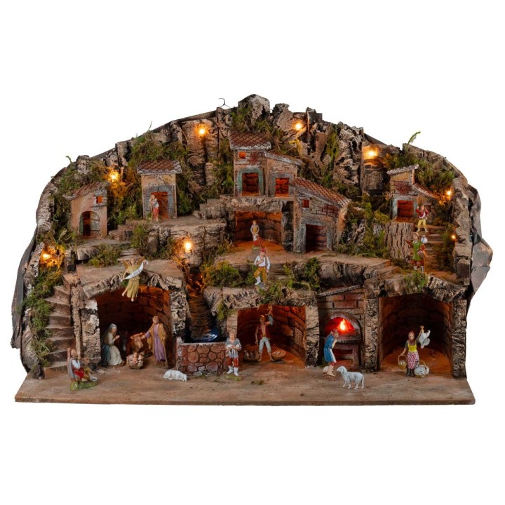 Illuminated nativity scene with caves, little houses, stream, and oven