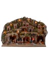 Illuminated nativity scene with caves, little houses, stream, and oven