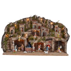 Illuminated nativity scene with caves, little houses, stream