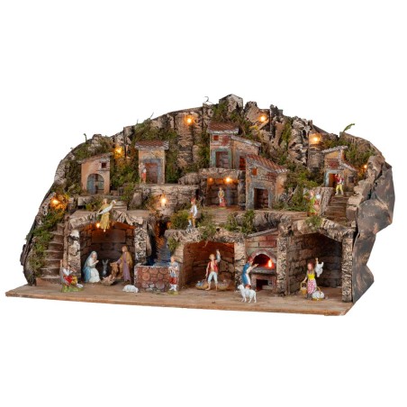 Illuminated nativity scene with caves, little houses, stream, and oven
