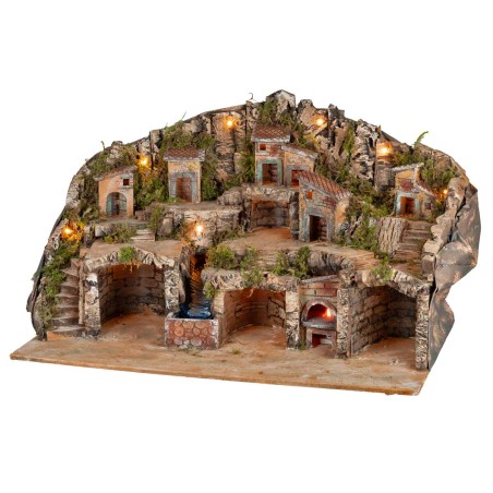 Belén iluminado con cuevas, casitas, arroyo y horno en