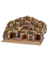 Illuminated nativity scene with caves, little houses, stream