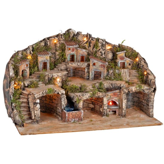 Illuminated nativity scene with caves, little houses, stream, and oven