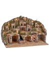 Illuminated nativity scene with caves, little houses, stream, and oven