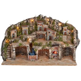 Illuminated nativity scene with caves, little houses, stream, and oven