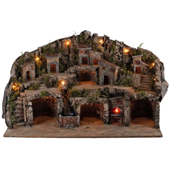 Illuminated nativity scene with caves, little houses, stream