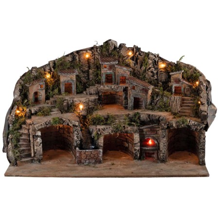 Illuminated nativity scene with caves, little houses, stream, and oven