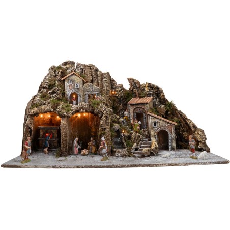 Illuminated nativity scene with oven and small waterfall