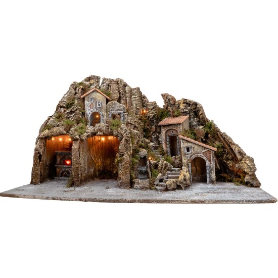 Illuminated nativity scene with oven and small waterfall