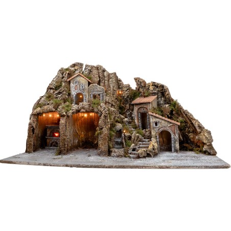 Illuminated nativity scene with oven and small waterfall