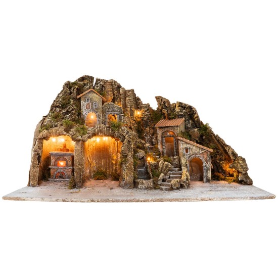 Illuminated nativity scene with oven and small waterfall