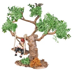 Niño sobre el columpio atado a un árbol para el belén