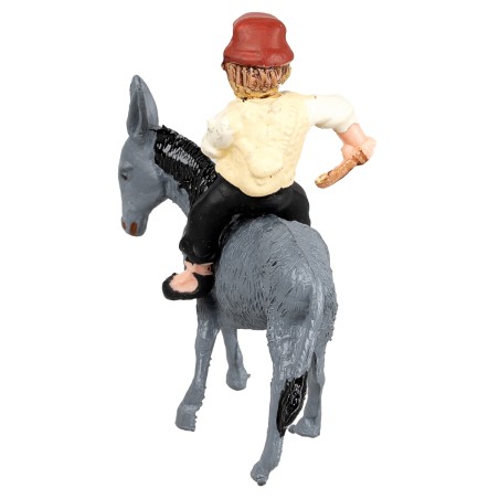 Man on a donkey transporting a cart loaded with hay for