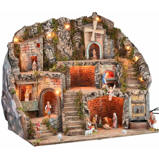 Illuminated nativity scene with statues, fountain, fire, and