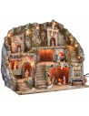 Illuminated nativity scene with statues, fountain, fire, and