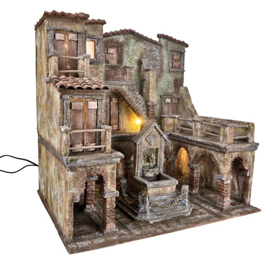 Borgo con piazza illuminata e fontana con pompa funzionante a