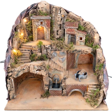 Illuminated nativity scene with fountain and donkey at the moving millstone