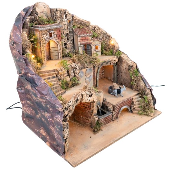 Illuminated nativity scene with fountain and donkey at moving millstone