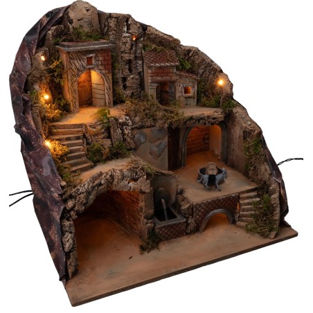Illuminated nativity scene with fountain and moving donkey at