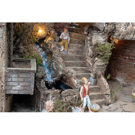 Presepe illuminato con statue, ruscello, forno e mulino a vento