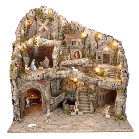 Illuminated nativity scene with statues, stream, oven and