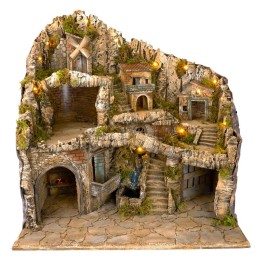 Illuminated nativity scene with statues, stream